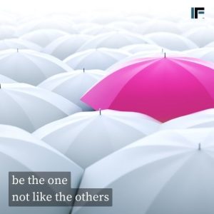 sea of white umbrellas with a pink umbrella standing out